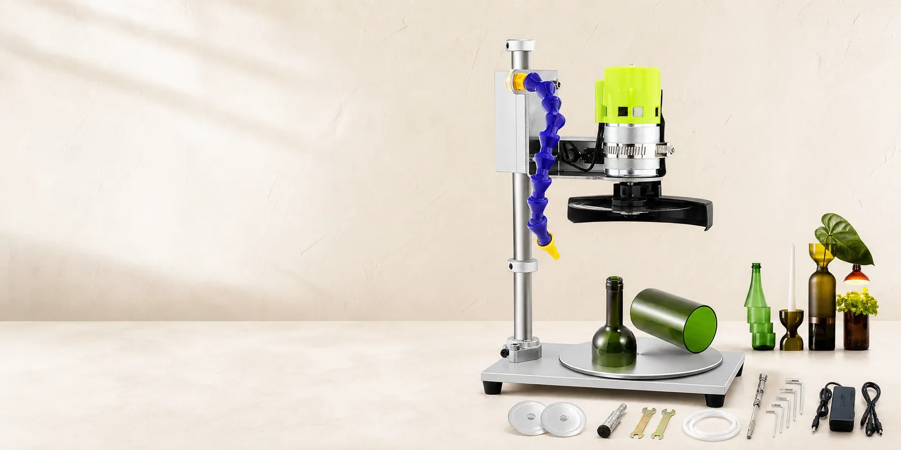 Premium electric glass bottle cutting machine on a clean work surface with various recycled glass bottle projects and included accessories, set against a neutral textured background with soft natural lighting.